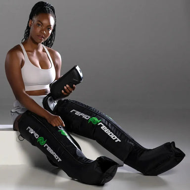 Woman using a black compression boots with 'Rapido Reboot' branding on a gray background