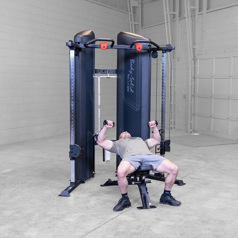 Man doing chest press with a bench on a Body-Solid Pro ClubLine S2CCX Series II Cable Column in black