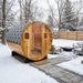 SunRay Galley 4 Person Barrel Sauna with Harvia 6kW Heater in a snowy outdoor setting with a fire pit and benches.