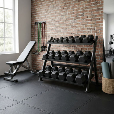 Gym interior with TKO-3-Tier-Horizontal-Dumbbell-Shelf-Rack-6235-with-Dumbbells, bench, and exercise equipment against a brick wall.