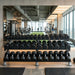 Gym interior with 5 LB- 100 LB dumbbells on a rack in a gym with exercise equipment.