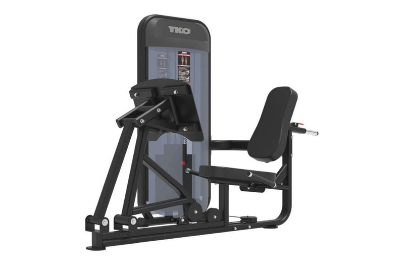 A TKO brand leg extension gym machine in black and gray, shown from a three-quarter angle on a solid white background.