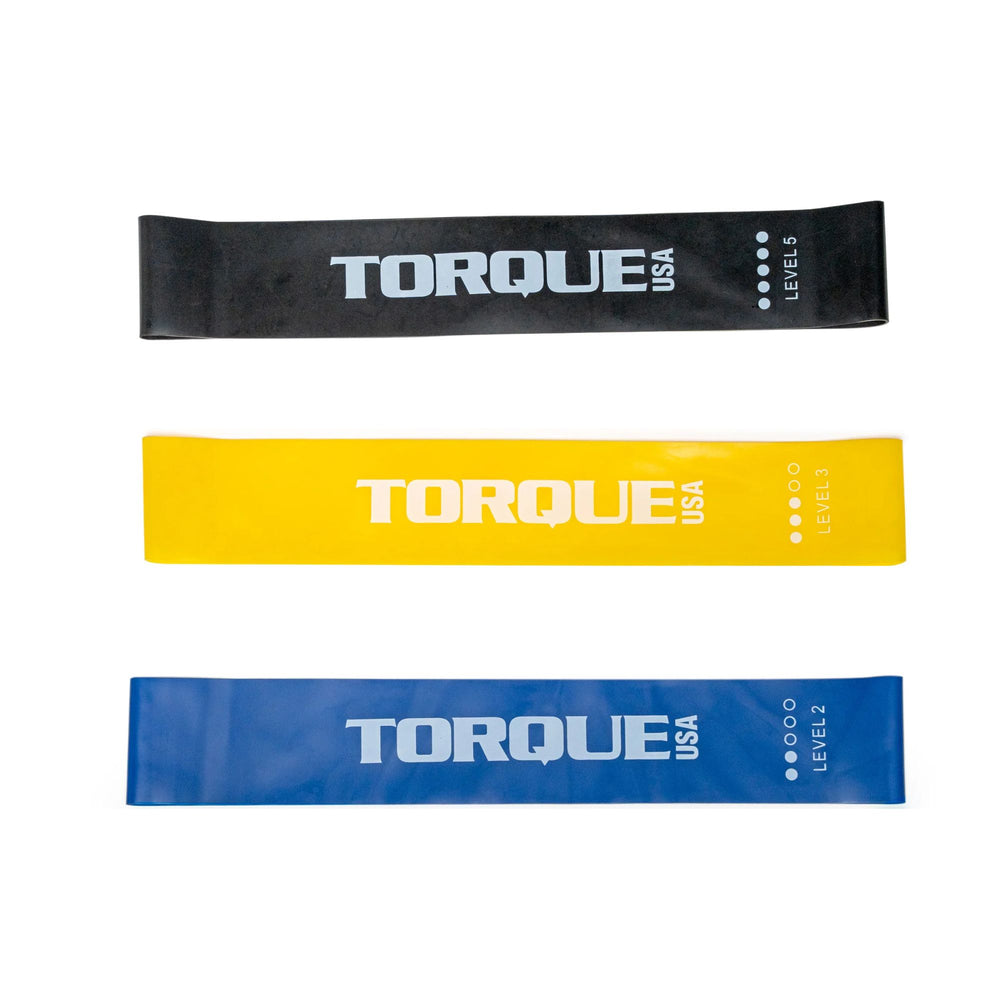 Three resistance bands from Torque USA in black, yellow, and blue on a white background.
