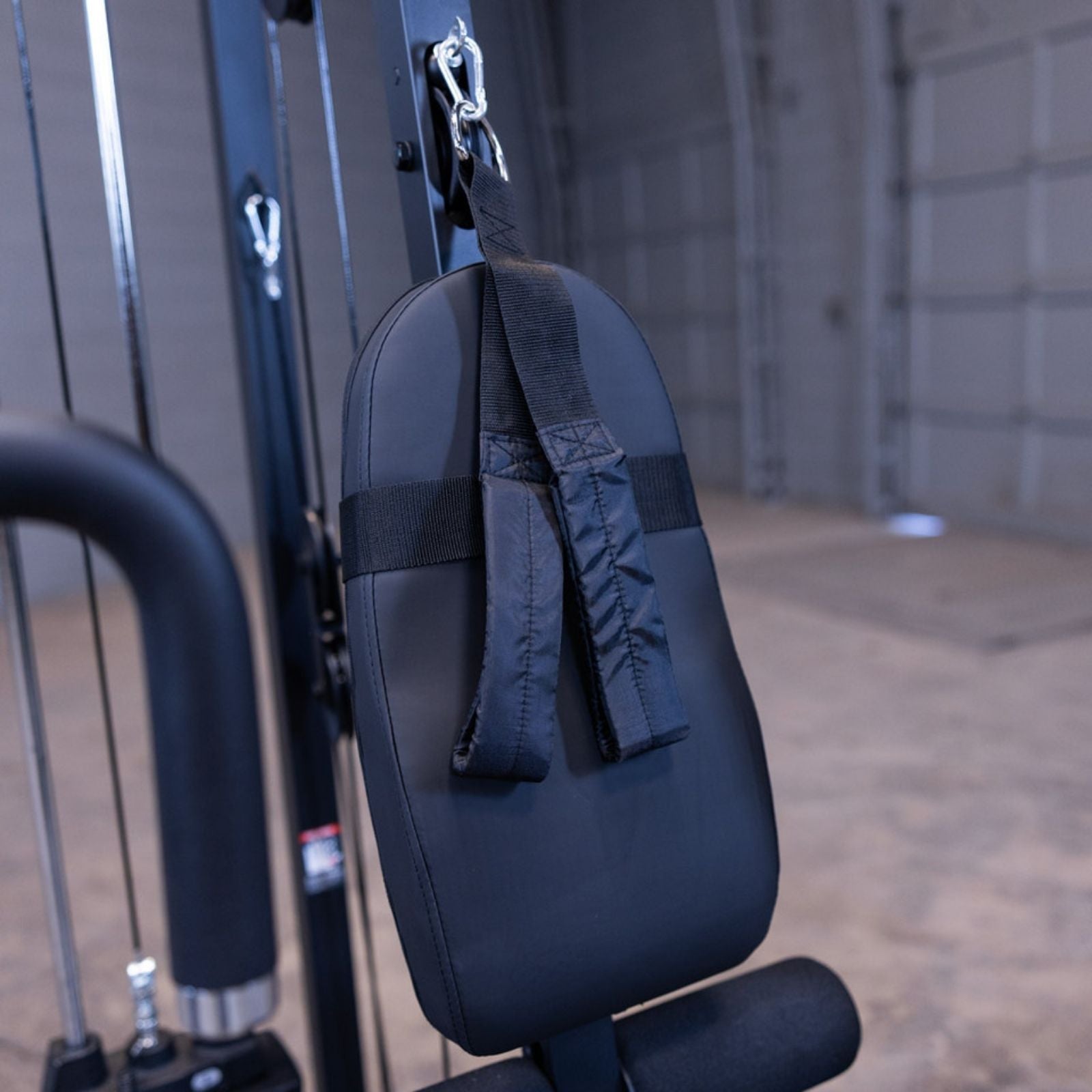 Close-up of the ab/triceps strap attachment clipped to the high pulley on the Body-Solid G1S Multi-Station Gym, resting against the back pad