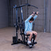 Man performing an ab crunch exercise on the Body-Solid G1S Multi-Station Gym using the mid pulley attachment