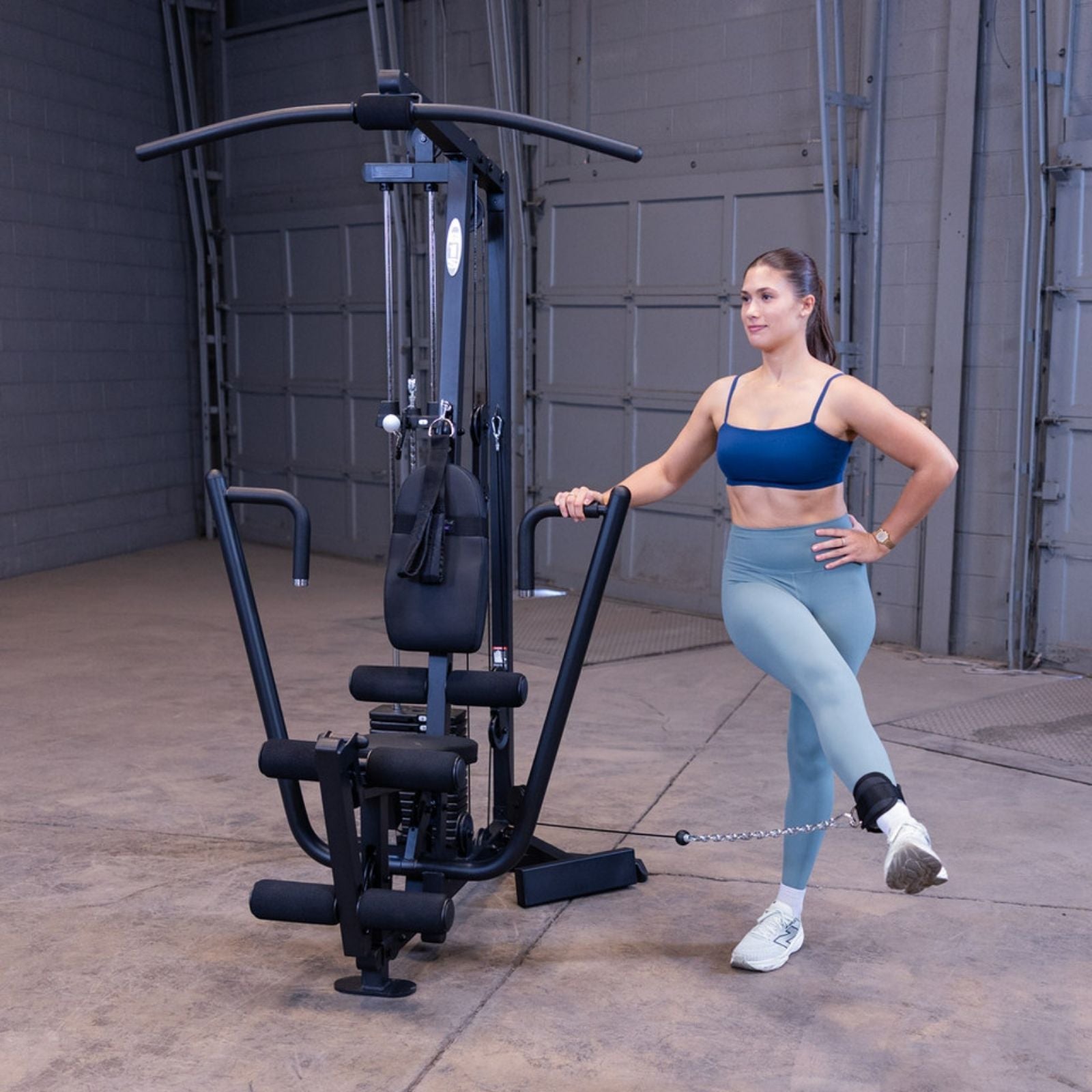 Woman performing a standing cable hip abduction on the Body-Solid G1S Multi-Station Gym using the low pulley and ankle strap