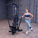 Woman performing a standing cable hip abduction on the Body-Solid G1S Multi-Station Gym using the low pulley and ankle strap