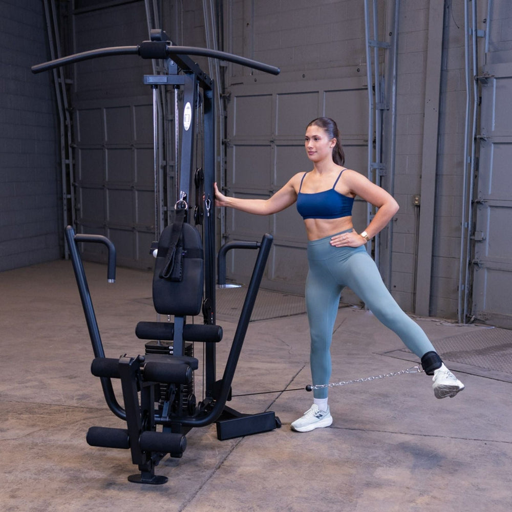 Woman performing a standing cable hip extension with abduction on the Body-Solid G1S Multi-Station Gym using the ankle strap and low pulley