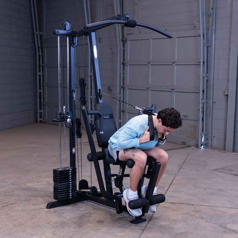 Man performing a high pulley ab crunch using the Body-Solid G1S Multi-Station Gym with ab strap attachment