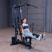 Woman performing a seated leg extension on the Body-Solid G1S Multi-Station Gym using the leg developer to target the quadriceps
