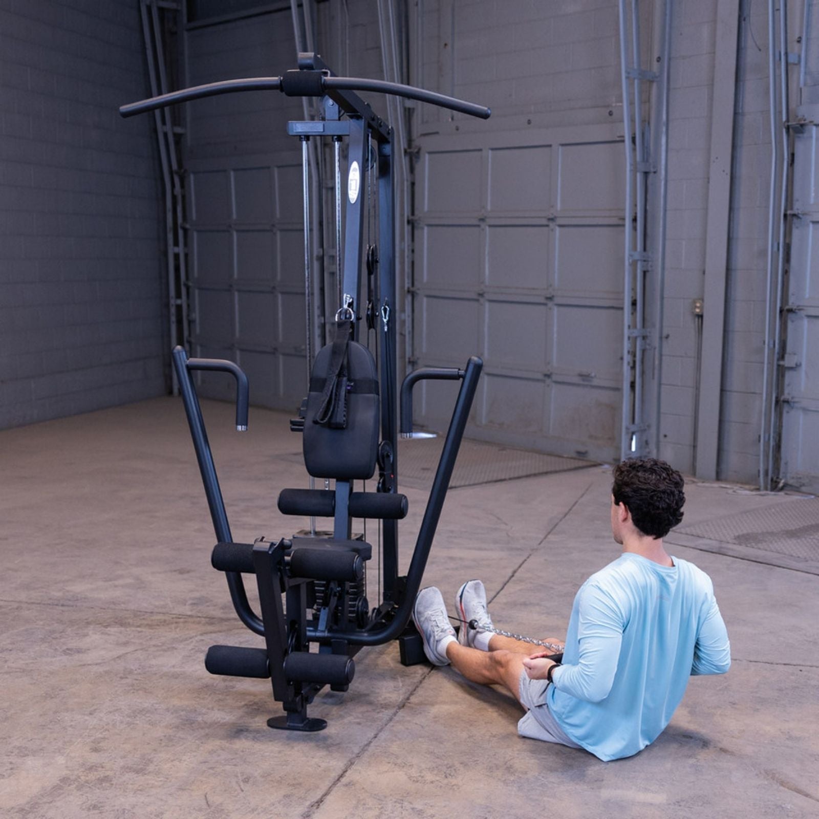 Man performing a seated low cable row on the Body-Solid G1S Multi-Station Gym using the low pulley and straight bar
