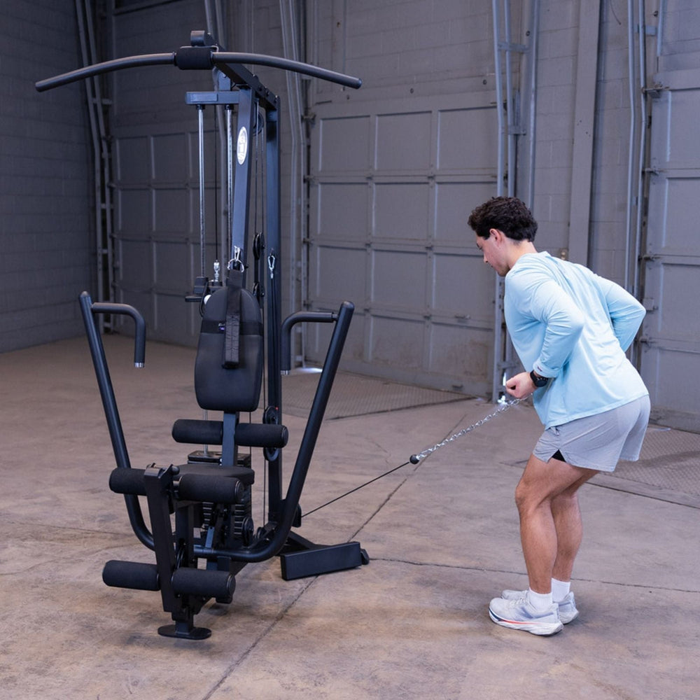 Man performing a standing low cable row on the Body-Solid G1S Multi-Station Gym, pulling a straight bar from the low pulley to his torso
