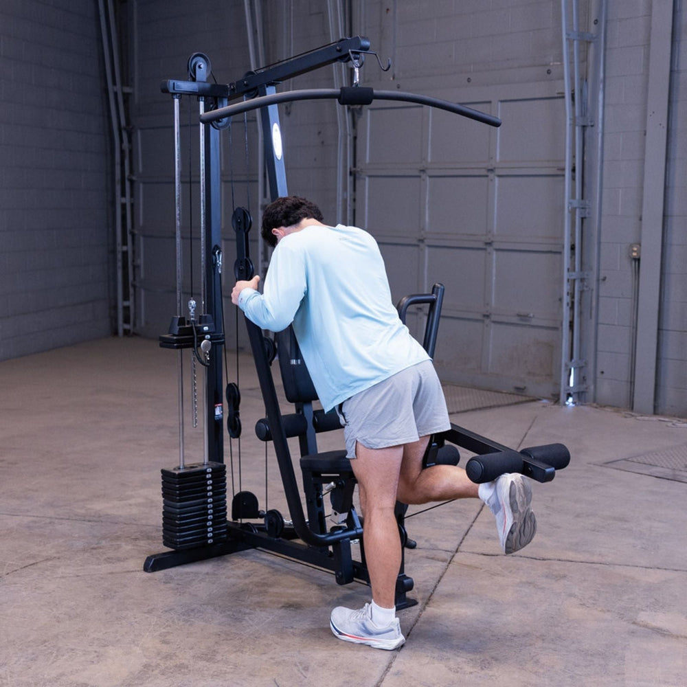 Man performing a standing single-leg hamstring curl on the Body-Solid G1S Multi-Station Gym, using the opposite leg from the previous image