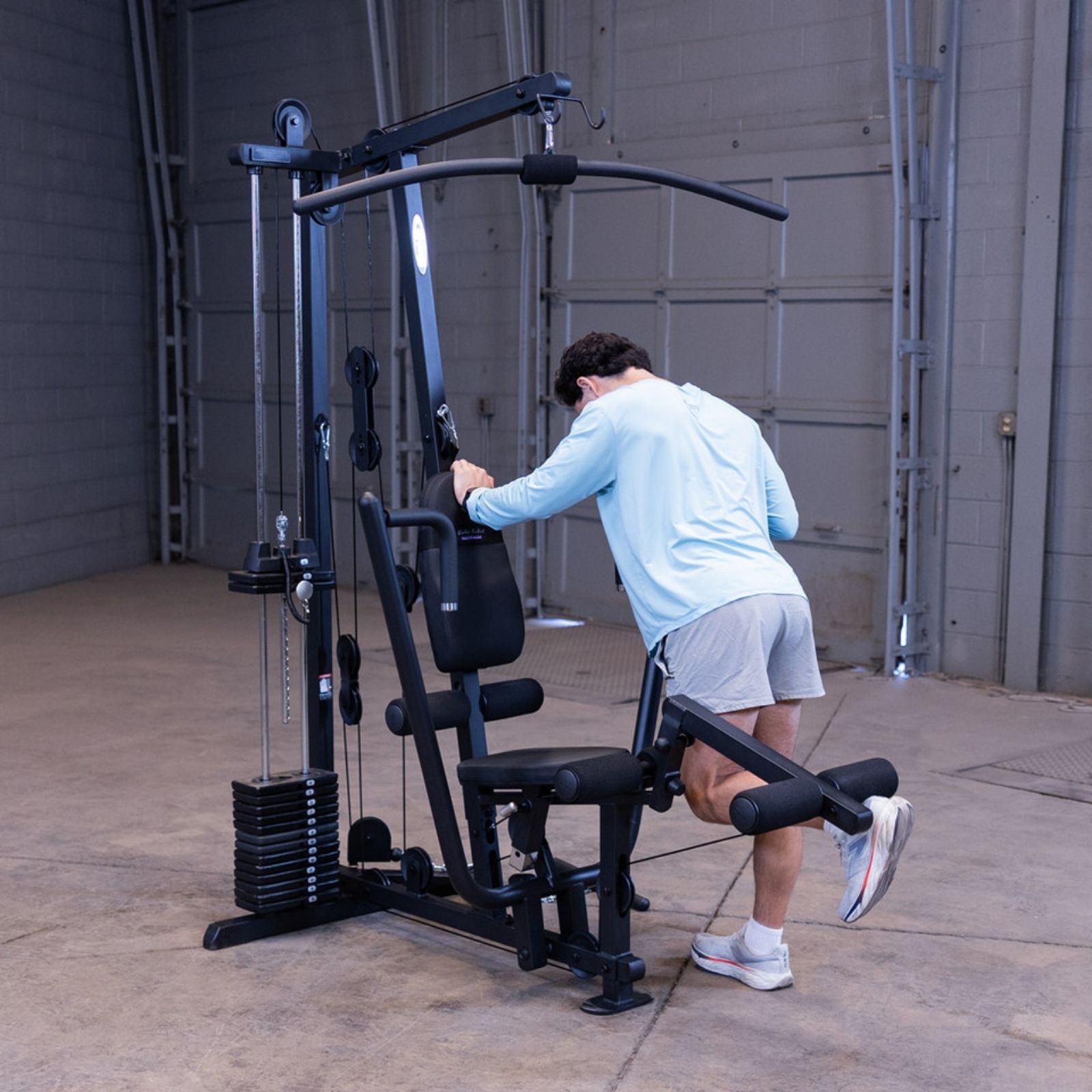 Man performing a standing single-leg hamstring curl using the leg developer on the Body-Solid G1S Multi-Station Gym