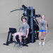 Body-Solid G9B dual stack home gym with two users demonstrating multi-station functionality
