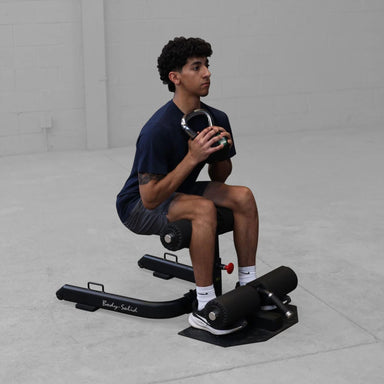 Man performing sissy squat on Body-Solid GSS50B targeting quadriceps