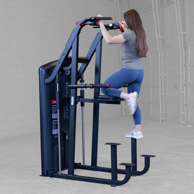 S2ACDX Series 2 Weight Assist Vertical Knee Raise Woman using a vertical pull-up machine in a gym setting