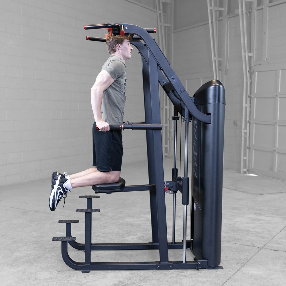 S2ACDX Series 2 Weight Assist Vertical Knee Raise Person using a black gym machine in a gray room