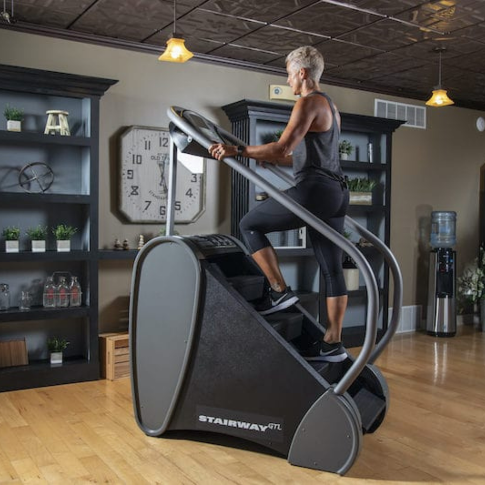 Person using a Stairway GTL stair climbing machine in a home setting.