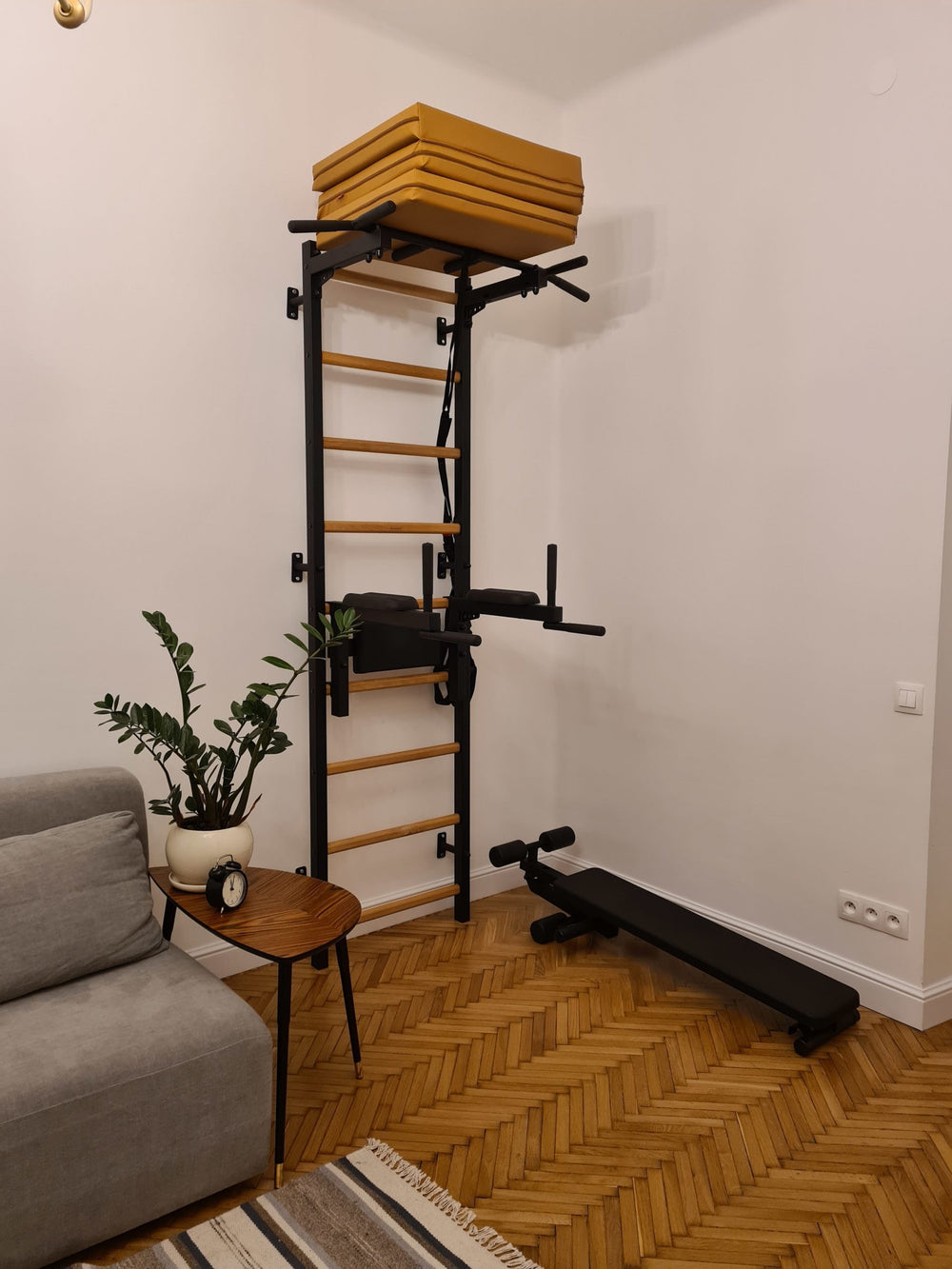 BenchK Foldable Gymnastic Mat - Brown put away on top of the wall bar set up pull up bars