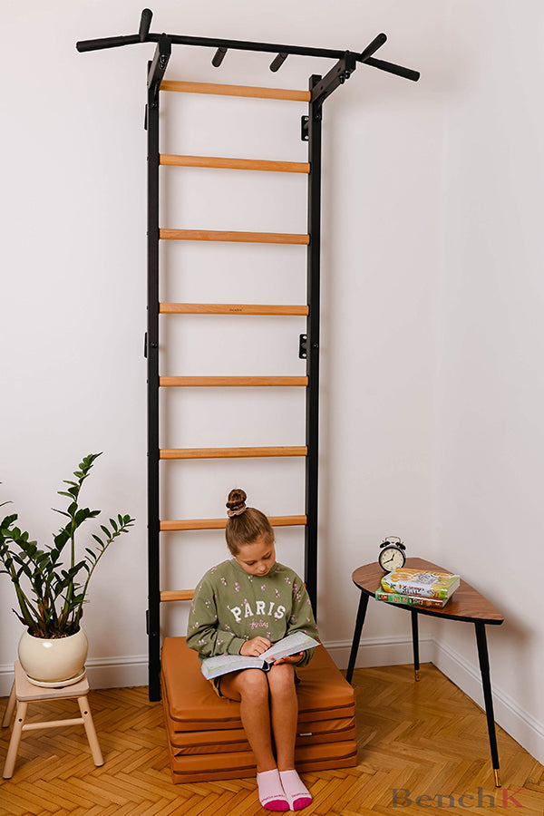 BenchK Foldable Gymnastic Mat - Brown with child model against a wall bar set up 