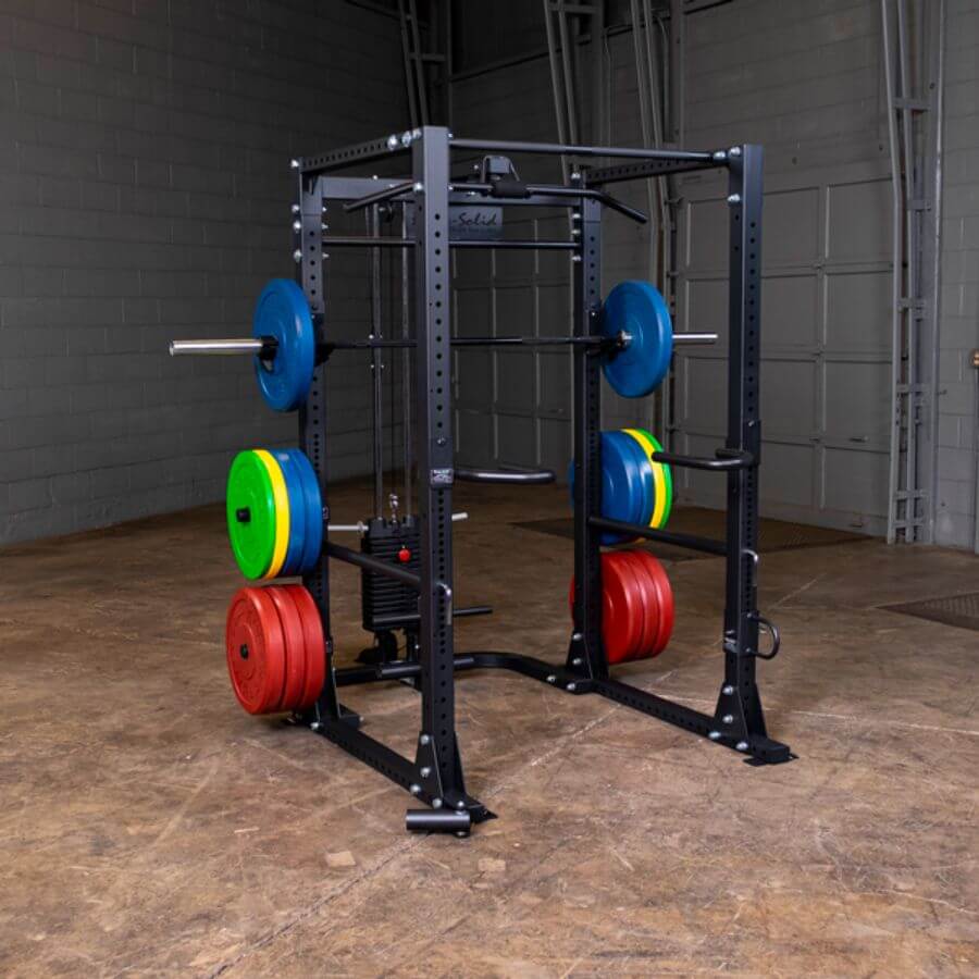 Gym power rack with Body-Solid Chicago Extreme Color Bumper Plates 260 LBs Set plates in a warehouse setting