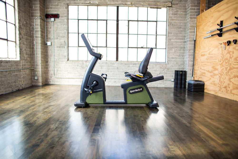 SportsArt Status Eco-Powr Recumbent Cycle G576R side view inside a home gym 