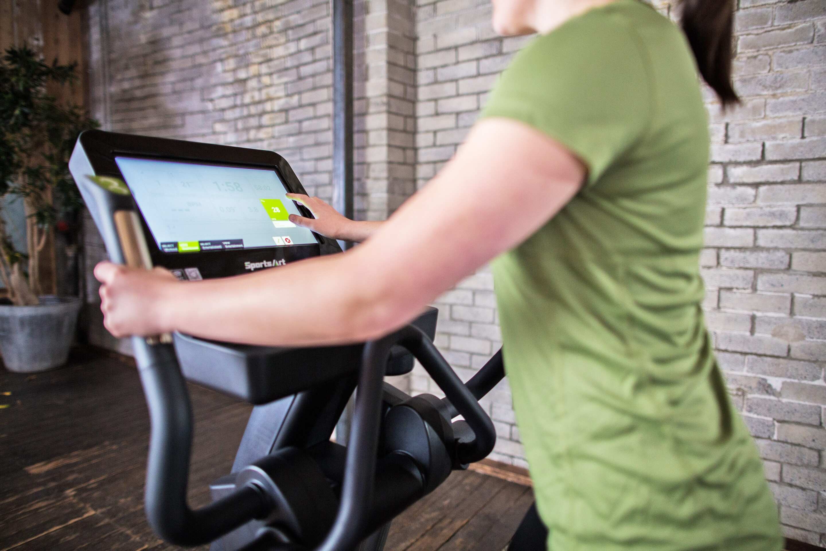 SportsArt Status Senza Elliptical-16 inch - E876-16 user interacting with the touch screen console 