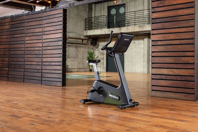 SportsArts Elite Eco-Powr Upright Cycle G574U front facing side view inside a gym 
