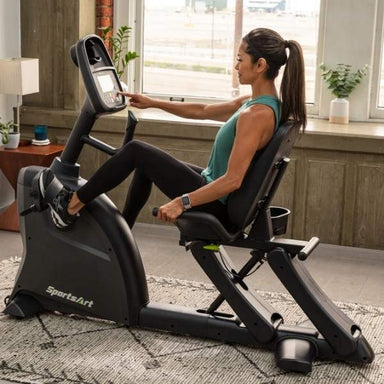 SportsArts Residential Recumbent Bike C55R with female user interacting with the touch screen 