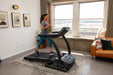SportsArts Residential Treadmill TR22F female user running on treadmill inside a home 