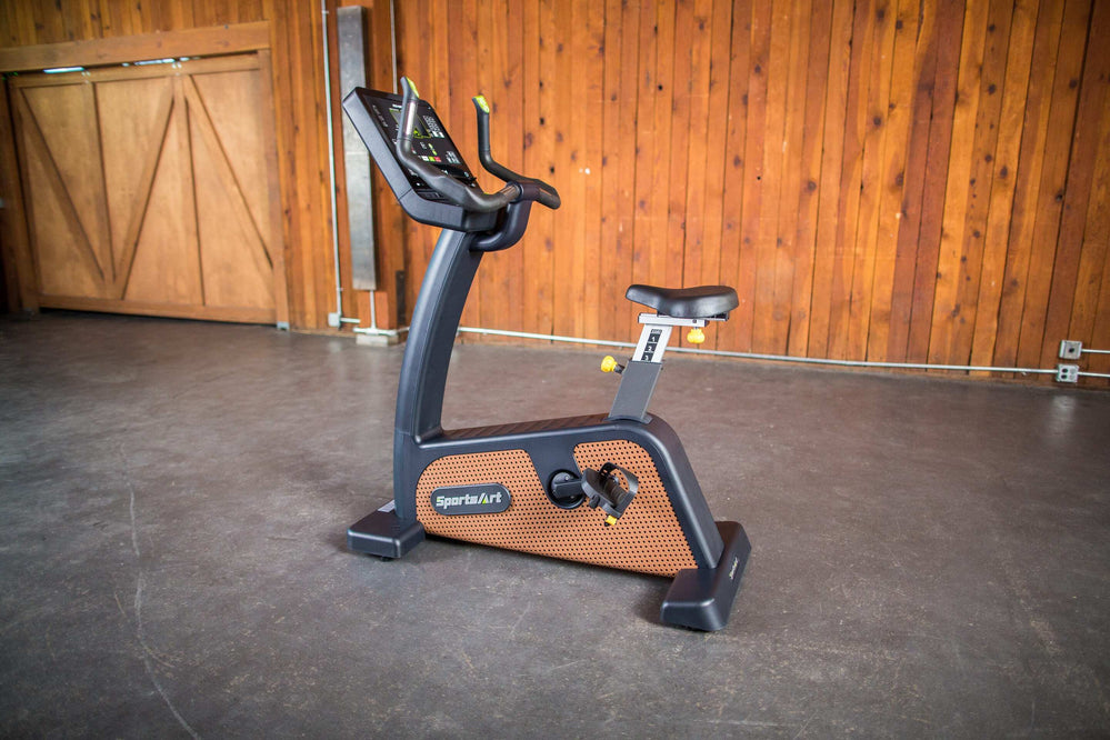SportsArts Status Eco-Natural Upright Cycle C576U side angle view in home gym setting