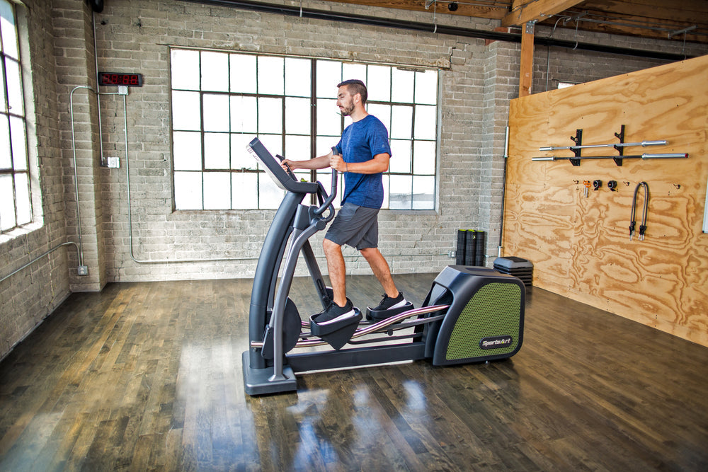SportsArts Status Eco-Powr Elliptical G876 male user exercising inside home gym 